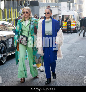 LONDON - 15. FEBRUAR 2019: Stilvolle Teilnehmer sammeln außerhalb 180 The Strand für die London Fashion Week. Ein blondes Mädchen trägt Sonnenbrille im grünen Mantel ein Stockfoto