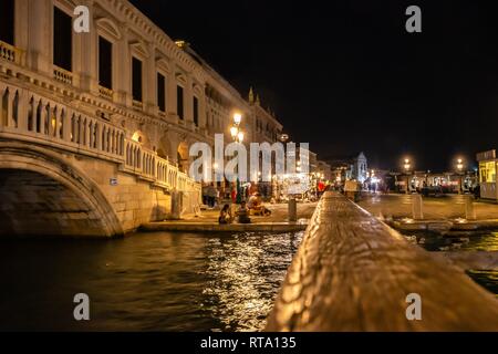 Venedig bei Nacht. Square San Marco. Verschwommene Silhouetten von Menschen sitzen auf der Pier Stockfoto