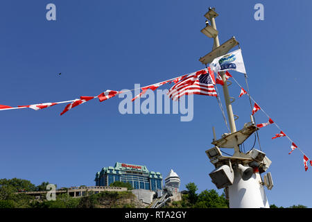 NIAGARA FALLS, ONTARIO, Kanada - 25. Juni 2018: Die kanadischen und amerikanischen Flagge am Mast von Niagara Kreuzfahrtschiff Stockfoto