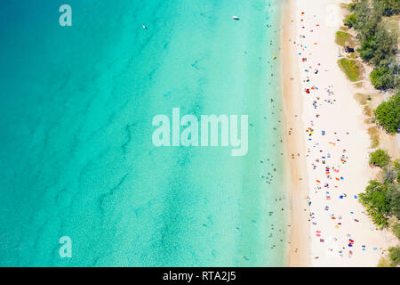 Ansicht von oben, aus der Vogelperspektive einen wunderschönen tropischen Strand mit weissem Sand, türkisklares Wasser und Menschen sonnenbaden, Surin Beach, Phuket, Thailand Stockfoto