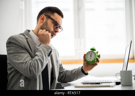 Junge Unternehmer arbeitet im Büro. Er ist spät im Zeitplan. Stockfoto