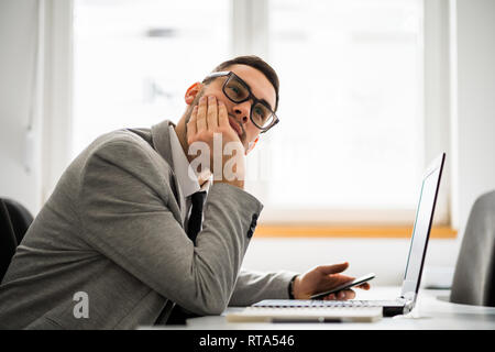 Junge Unternehmer arbeitet im Büro. Er wartet auf einen Anruf. Stockfoto