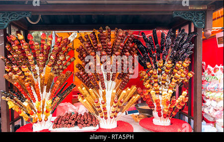 Die traditionelle lokale chinesische Essen: mit Zucker überzogen Haws an einem klebt auf dem Messestand Stockfoto