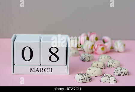 Internationaler Tag der Frauen Konzept. Weiß Holzwürfel mit 8. März und Blumen auf pastellfarbenen Hintergrund. Platz kopieren Stockfoto