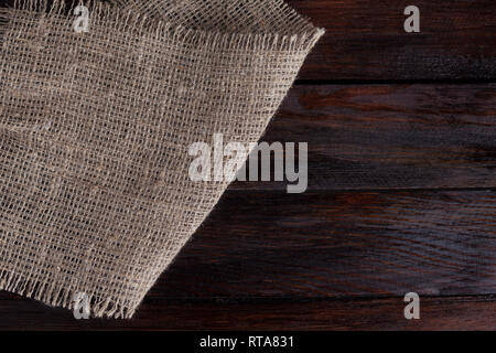 Retro alte Flachs Gewebe. Stück auf dunklen vintage Holz- Hintergrund. Stockfoto