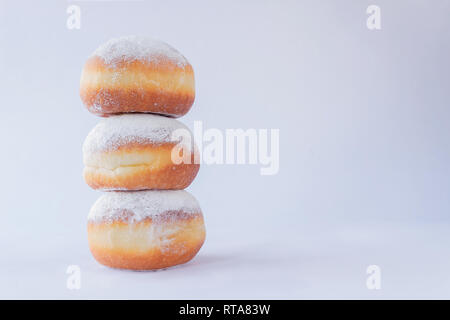 Drei frische Donuts auf einander gestapelt auf weißem Hintergrund Stockfoto