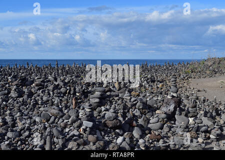 Blick auf den Strand in Puerto de la Cruz auf Teneriffa, wo die Kieselsteine in Stapel von Kieseln angeordnet wurden. Stockfoto