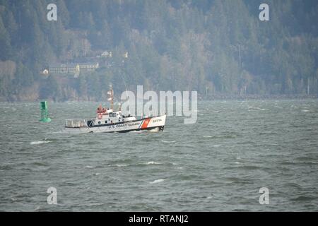 Die Crew der 52-Fuß-Motor Life Boat Triumph II, von Station Cape Enttäuschung, pass Boje 4 auf dem Columbia River in der Nähe von Hammond, Erz, während ein Abschleppen des kommerziellen Fischfangs Schiff Kapitän Raleigh, Feb 7, 2019. Der Kapitän Raleigh erlitt ein Untersetzungsgetriebe 3 Meilen vor der Küste von Cannon Beach, Erz, Krabbe Töpfe in der Dungeness crab Saison. Us-Küstenwache Stockfoto