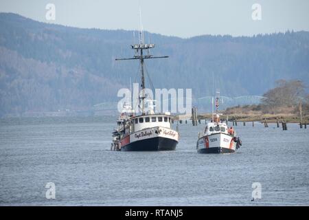 Die Crew der 52-Fuß-Motor Life Boat Triumph II, von der Coast Guard Station Cape Enttäuschung, betritt die Skipanon Marina in Warrenton, Erz, während die kommerzielle Fischerei Schiff Kapitän Raleigh, Feb 7, 2019 abschleppen. Die 52-Fuß-MLB hat den besten Anhängelast und Übertragungsbereich aller aktiven Küstenwache kleine Boote. Us-Küstenwache Stockfoto