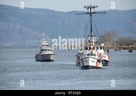 Die Crew der 52-Fuß-Motor Life Boat Triumph II, von der Coast Guard Station Cape Enttäuschung, schleppt die 112 brutto - Tonne kommerzielle Fischerei Schiff Kapitän Raleigh in der Skipanon Marina in Warrenton, Erz, Feb 7, 2019. Die 52-Fuß-MLB hat drei Mal die Reichweite und fünf Mal die Zugkraft des 47-Fuß-MLB Bild im Hintergrund. Us-Küstenwache Stockfoto