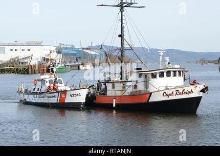 Die Crew an Bord der 52-Fuß-Motor Life Boat Triumph II, von der Coast Guard Station Cape Enttäuschung, schließt die 9-Stunde Abschleppen des kommerziellen Fischfangs Schiff Kapitän Raleigh innerhalb der Skipanon Marina in Warrenton, Erz, Feb 7, 2019. Die Abschlepp-trennvorrichtung war etwa 3 Meilen vor der Küste von Cannon Beach, Erz, und Skipanon Marina. Us-Küstenwache Stockfoto