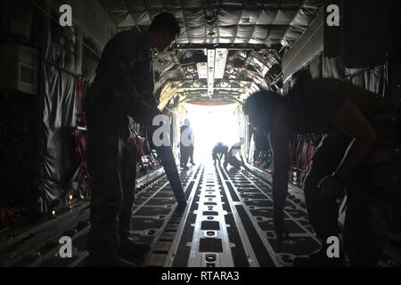 Us-Flieger auf der 75th Expeditionary Airlift Squadron zugeordnet vorbereiten Ladung auf einem Super C-130J Hercules im Camp Lemonnier, Dschibuti, Feb 1, 2019 zu erhalten. 75 EAS bietet taktischer Lufttransport zu unterstützen und Einheiten in Afrika unterstützen. Stockfoto