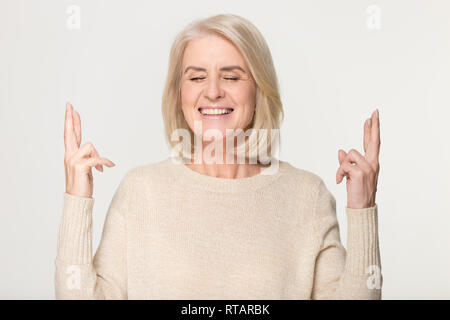 Gerne Frau mittleren Alters die Daumen in der Hoffnung auf gutes Glück Stockfoto