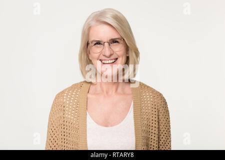 Glückliche alte Frau in Gläsern auf Hintergrund, Porträt Stockfoto