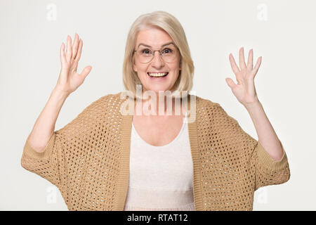 Aufgeregt reife Frau Gefühl erstaunt auf grauem Hintergrund Stockfoto