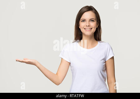 Happy girl Holding copy Space Advertising auf grauem Hintergrund Stockfoto