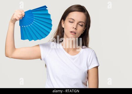 Müde junge Frau das Gefühl überhitzt Leiden von Hitze winken Ventilator Stockfoto