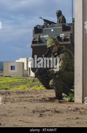 Japan Masse Verteidigung-kraft (JGSDF) Soldat mit 1 amphibische Rapid Deployment Regiment, Patrouillen neben einem Angriff amphibischen Fahrzeugen durch städtische Maßnahmen während einer amphibischen Landung Übung für Eiserne Faust2019, 24.02.4, US Marine Corps Base Camp Pendleton, Ca. Übung Iron Fist ist eine jährliche, multilateralen Ausbildung Übung, in der US-amerikanischen und japanischen Service Mitglieder trainieren gemeinsam und teilen Techniken, Taktiken und Verfahren der operativen Fähigkeiten zu verbessern. Stockfoto