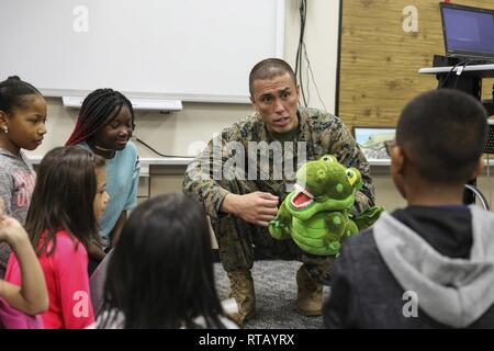 Petty Officer 2nd class Mark D. Abundo spricht mit Studenten über die Bedeutung der Mundgesundheit Feb 5, 2019 auf Lager Kinser, Okinawa, Japan. Segler aus Naval Kliniken in Okinawa hielt eine Präsentation Mundgesundheit Bewußtsein während National Children's zahnmedizinischen Monat Gesundheit zu fördern. Abundo, ein Krankenhaus Corpsman mit Verzweigung zahnmedizinische Klinik Kinser, 3 zahnmedizinische Bataillon, 3. Marine Logistics Group, ist ein Eingeborener von Camarillo, Kalifornien. Stockfoto