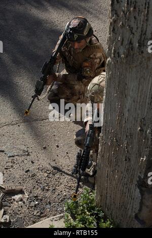 Irakische Terrorismusbekämpfung Service Basic Leader Kurs Schüler nehmen während sie auf dem Weg zu einem Ziel in einer praktischen Übung in der Nähe von Bagdad, Irak, Feb 5, 2019. BLC lehrt und Nachwuchsführungskräfte die Fähigkeiten und die Maßnahmen, die erforderlich sind, um Ihre individuellen Führungsfähigkeiten zu entwickeln. Streitkräfte der Koalition beraten und den irakischen Ausbilder in einer gemeinsamen Anstrengung eine Elite zu bauen helfen, sich selbst tragende Kraft, der Irak souveränen Grenzen sichern kann, zum Schutz der Bevölkerung und der dauerhaften Niederlage von ISIS gewährleisten. Stockfoto