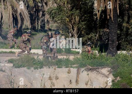 Irakische Terrorismusbekämpfung Service Basic-Kurs (BLC) Studierende in Richtung Ziel während ihrer Ausbildung eine praktische Übung, die kombiniert Unterricht in land Navigation, Durchführung von squad Bewegung, und Reagieren in der Nähe von Bagdad, Irak, Feb 5, 2019 zu kontaktieren. BLC ist von irakischen Ausbilder mit Hilfe von Alliierten Streitkräften geführt und bereitet Soldaten CTS Soldaten, führende Rollen im Team und Gruppe das Niveau von Führungskompetenzen, Ausbildung, und warfighting Konzepte und Fähigkeiten. Streitkräfte der Koalition beraten und den irakischen Ausbilder in einer gemeinsamen Anstrengung eine Elite zu bauen helfen, sich selbst tragenden Stockfoto