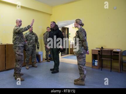 ŚWIĘTOSZÓW, Polen (Feb. 5, 2019) - Armee Cpl. Robert Pugsley und SPC. Rhea Redmond, Bekämpfung der Mediziner in der Medizinischen Platoon, 1 Staffel, 4 U.S. Cavalry Regiment aus Fort Riley, Kan., diskutieren Sie mit Vincent "B.J." Lawrence, der Oberbefehlshaber der Kriegsveteranen der USA, die Besonderheiten des Bataillons medizinische Einrichtung auf Świętoszów, während das Gerät auf dem Boden ist. Als Kommandant der VFW, Lawrence persönlich die Soldaten der 1-4 Kavallerie besucht, als in einer Bemühung, besser die Ausbildung Umwelt verstehen mobilisiert und die Lebensbedingungen der Soldaten Statione Stockfoto