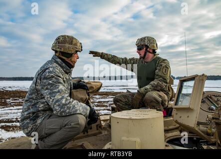 ŚWIĘTOSZÓW, Polen (Feb. 6, 2019) - Sgt. Michael Messersmith, ein M1 Abrams Tank Gunner mit der 1. Staffel, 4 U.S. Cavalry Regiment aus Fort Riley, Kan., erläutert die Funktionen des M1 Abrams Tank zu Vincent "B.J." Lawrence, der Oberbefehlshaber der Kriegsveteranen der USA, vor einem live-fire Übung an einem Schießplatz in der Nähe von Świętoszów. Als Kommandant der VFW, Lawrence persönlich die Soldaten der 1-4 Kavallerie besucht, als in einer Bemühung, besser die Ausbildung Umwelt verstehen mobilisiert und die Lebensbedingungen der Truppen in Übersee, in Unterstützung der O stationiert Stockfoto