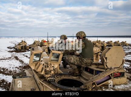 ŚWIĘTOSZÓW, Polen (Feb. 6, 2019) - Sgt. Michael Messersmith, ein M1 Abrams Tank Gunner mit der 1. Staffel, 4 U.S. Cavalry Regiment aus Fort Riley, Kan., erläutert die Funktionen des M1 Abrams Tank zu Vincent "B.J." Lawrence, der Oberbefehlshaber der Kriegsveteranen der USA, vor einem live-fire Übung an einem Schießplatz in der Nähe von Świętoszów. Als Kommandant der VFW, Lawrence persönlich die Soldaten der 1-4 Kavallerie besucht, als in einer Bemühung, besser die Ausbildung Umwelt verstehen mobilisiert und die Lebensbedingungen der Truppen in Übersee, in Unterstützung der O stationiert Stockfoto