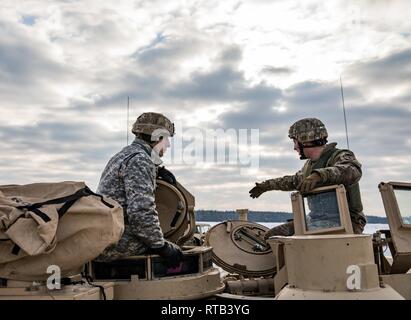 ŚWIĘTOSZÓW, Polen (Feb. 6, 2019) - Sgt. Michael Messersmith, ein M1 Abrams Tank Gunner mit der 1. Staffel, 4 U.S. Cavalry Regiment aus Fort Riley, Kan., erläutert die Funktionen des M1 Abrams Tank zu Vincent "B.J." Lawrence, der Oberbefehlshaber der Kriegsveteranen der USA, vor einem live-fire Übung an einem Schießplatz in der Nähe von Świętoszów. Als Kommandant der VFW, Lawrence persönlich die Soldaten der 1-4 Kavallerie besucht, als in einer Bemühung, besser die Ausbildung Umwelt verstehen mobilisiert und die Lebensbedingungen der Truppen in Übersee, in Unterstützung der O stationiert Stockfoto