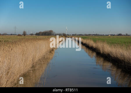 Entwässerungskanal und wind turbine. In der Nähe von Norden. Ostfriesland. Niedersachsen. Deutschland. Stockfoto