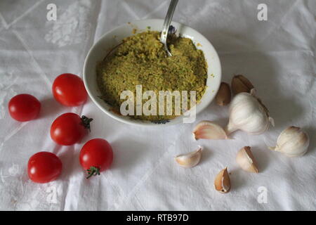 Würzige guacamole in Schüssel mit Sweet Cherry Tomaten und Knoblauch auf Snack Stockfoto