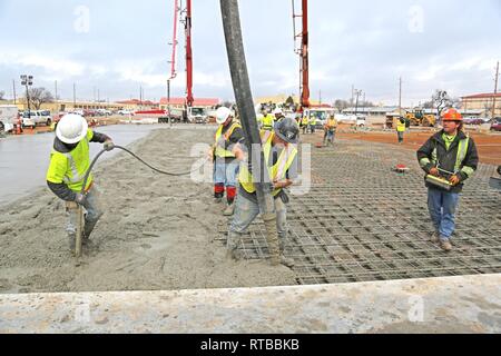 Us-Armee Korps der Ingenieure, Tulsa Bezirk, Auftragnehmer mit einer Pumpe lkw-Boom (Mitte) und konkrete immersion Vibrator (links) Konkrete auf Fort Sill als Teil einer Ausbildung Support facility Bauvorhaben Ort, 2. Feb 2018. Stockfoto