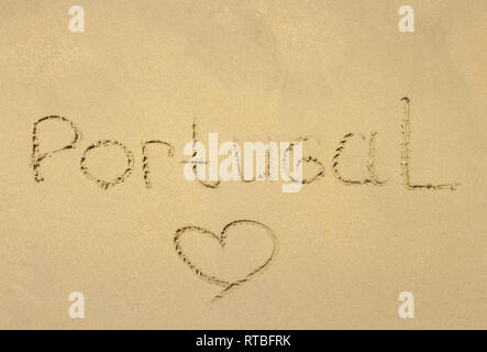 Inschrift auf nassem Sand Portuga und das Herz gemalt auf dem Sand als Symbol der Liebe. Cascais, Portugal Stockfoto