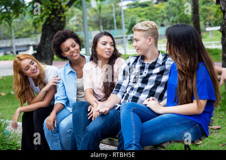 Gruppe von lateinamerikanischen und afrikanischen Jungen Erwachsenen im Freien auf dem Campus der Universität Stockfoto