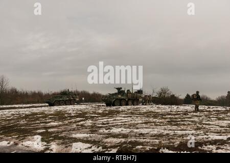 Soldaten zu Charlie Truppe, 1.Staffel, 2d-Cavalry Regiment aus Vilseck, Deutschland, machen Sie eine Pause nach einer Iteration auf den situativen Übung Lane im Bereich Bravo und Zulu, auf dem Truppenübungsplatz Baumholder, Baumholder, Deutschland, Feb 7, 2019. 1/2CR führt derzeit den Betrieb Kriegsadler platoon-taktischen Kenntnisse, squadron Unterstützung Wirksamkeit und die gesamten organisatorischen Letalität zu entwickeln. Stockfoto