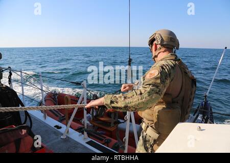 ARABIAN GULF (Feb. 07, 2019) von der U.S. Coast Guard Bootsmann Mate 1. Klasse Ted Tochterman senkt ein kleines Boot an Bord Insel-Klasse Patrouillenboot USCGC Maui (WPB 1304). Maui ist Vorwärts - in die USA 5 Flotte Bereich der Maßnahmen zur Unterstützung der Marine im Einsatz für die Stabilität und Sicherheit in der Region zu gewährleisten und verbindet das Mittelmeer und den Pazifischen Raum durch den westlichen Indischen Ozean und drei strategischen Punkten ersticken. Stockfoto