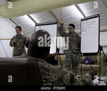 Spc. Johnathan Ramirez mit der speziellen Truppen Bataillon, 300 Sustainment Brigade, Freiwilligen, die eine Frage in Bezug auf die Armee Fragen - Pflege - Escort (ACE) Selbstmord Intervention Training von Kaplan (1. Lt.) Amy Gerechtigkeit im Camp Arifjan, Kuwait, Feb 8, 2019 zu beantworten. Stockfoto