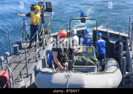 ARABIAN GULF (Feb. 9, 2019) Chief's Bootsmann Mate Luichy Victorianoabrej, Links, leitet eine starre - Rumpf Schlauchboot Übung an Bord der Cyclone-Klasse Coastal Patrol Schiff USS Thunderbolt (PC 12). Thunderbolt ist, nach vorn auf die US-Flotte 5 Bereich der Maßnahmen zur Unterstützung der Marine im Einsatz für die Stabilität und Sicherheit in der Region zu gewährleisten und verbindet das Mittelmeer und den Pazifischen Raum durch den westlichen Indischen Ozean und drei strategischen Punkten ersticken. Stockfoto