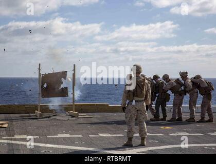 Mittelmeer (Feb. 11, 2019) - US-Marines auf den 22 Marine Expeditionary Unit brace, während ein "Donut" explodiert bei einer Live-fire Hosen Übung auf dem Flugdeck der San Antonio-Klasse amphibious Transport dock Schiff USS Arlington LPD (24), 24.02.11, 2019. Arlington einen geplanten Einsatz als Teil der 22 MEU und der kearsarge Amphibischen bereit, zur Unterstützung der Maritime Security Operations, Krisenbewältigung und Theater Zusammenarbeit im Bereich Sicherheit und zugleich eine vorwärts Naval und Marine Präsenz. Stockfoto