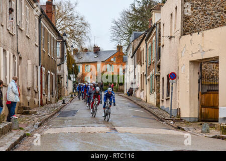 Dampierre-en-Yvelines, Frankreich - 4. März 2018: Das Peloton aproaching auf einer kleinen traditionellen Straße in einem französischen Dorf bei Paris-nizza 2018. Stockfoto