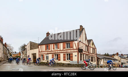 Dampierre-en-Yvelines, Frankreich - 4. März 2018: Das Peloton passiert vor der traditionellen Gebäude in einer kleinen Straße in einem französischen Dorf während Pari Stockfoto