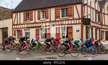 Dampierre-en-Yvelines, Frankreich - 4. März 2018: Das Peloton passiert vor der traditionellen Gebäude in einer kleinen Straße in einem französischen Dorf während Pari Stockfoto