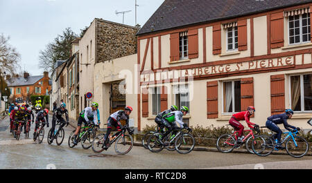 Dampierre-en-Yvelines, Frankreich - 4. März 2018: Das Peloton passiert vor der traditionellen Gebäude in einer kleinen Straße in einem französischen Dorf während Pari Stockfoto