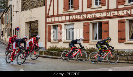 Dampierre-en-Yvelines, Frankreich - 4. März 2018: die Gruppe der Radfahrer ridig vor der traditionellen Gebäude in einer kleinen Straße in einem französischen Dorf während Stockfoto