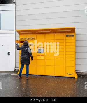 Straßburg, Frankreich - Feb 8, 2018: Junge Frau Amazon Spind die Self-service-Paketdienst Station in der Nähe von Auchan Supermarkt die Tür öffnen Blick in Karton abrufen Stockfoto