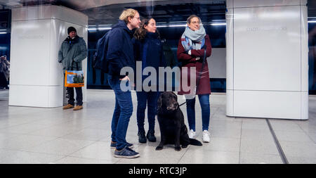 HAMBURG, DEUTSCHLAND - Mar 22, 2018: Drei Freunde mit einem Hund in der U-Bahn Stockfoto