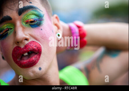 RIO DE JANEIRO - Februar 25, 2017: Ein brasilianischer Mann feiert Karneval mit einer Parodie Kostüm mit bunten Make-up zu einem Straßenfest. Stockfoto