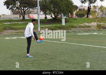 San Diego (Feb. 09, 2019) Seaman Allen Stewart, zugeordnet zu den Flugzeugträger Theodore Roosevelt (CVN-71), spielt mit einem Fußball als Teil seiner körperlichen Fitness Training am Naval Air Station North Island. Seaman Stewart integriert Fußball in seine körperliche Fitness Therapieschema, das Spielen der Sport für drei Stunden jedes Wochenende, um in Form zu bleiben. Stockfoto