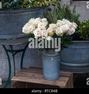 Die weißen Rosen auf einem Hocker am Eingang des Flower Shop Stockfoto