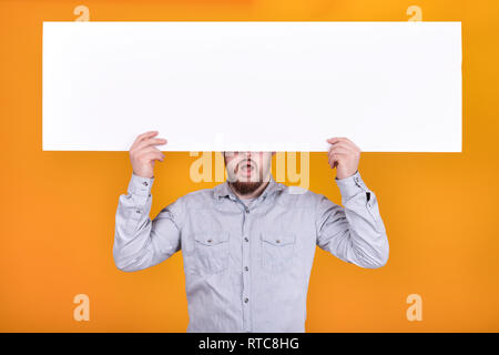 Ein Mann hält ein Plakat für Text, ausdrucksstarken Shouts und einladenden Käufer Stockfoto